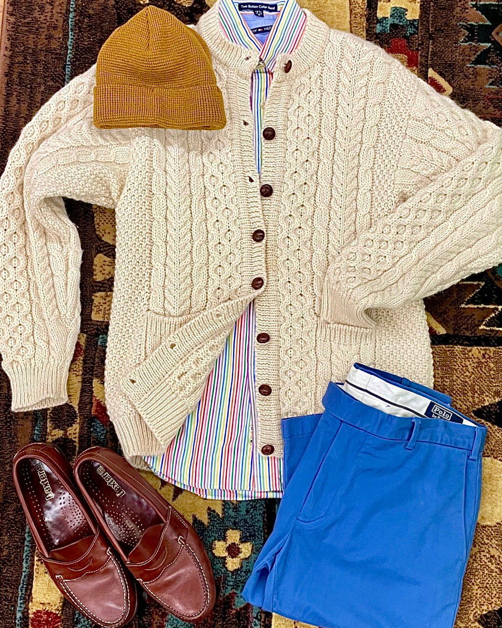 wool cable-knit cardigan sweater styled with a pair of penny loafers, blue chinos & pinstripe shirt
