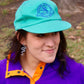 Eddie Bauer high-crown, structured cap in turquoise color with vintage goose logo in purple