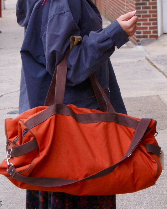 large orange vintage duffel bag with brown details & straps