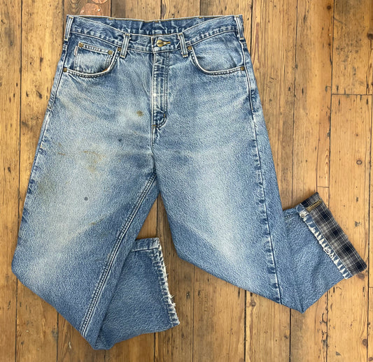 faded vintage jeans with blue-gray flannel lining and some stains on the front 