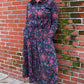 long dress with long sleeves and fitted elastic waist, featuring a red & yellow floral print on black jersey material 