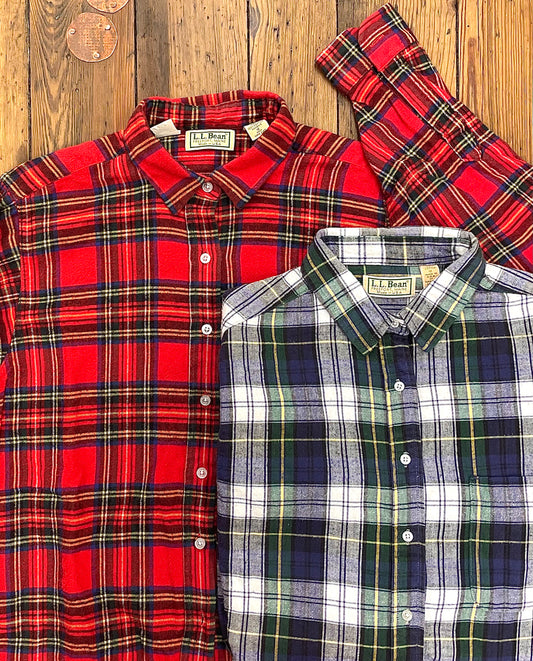 two traditional plaid flannel shirts, one red with green & yellow, the other blue with white, yellow & green
