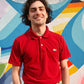 Model wears dark red polo shirt with classic alligator emblem on chest.