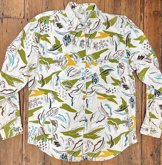 white button-up shirt with green-yellow-brown abstract print resembling leaves  