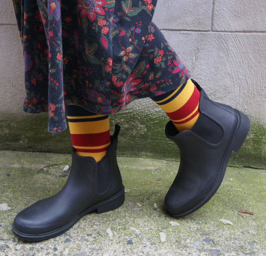 black rubber rain boots with ankle length, styled with yellow striped socks