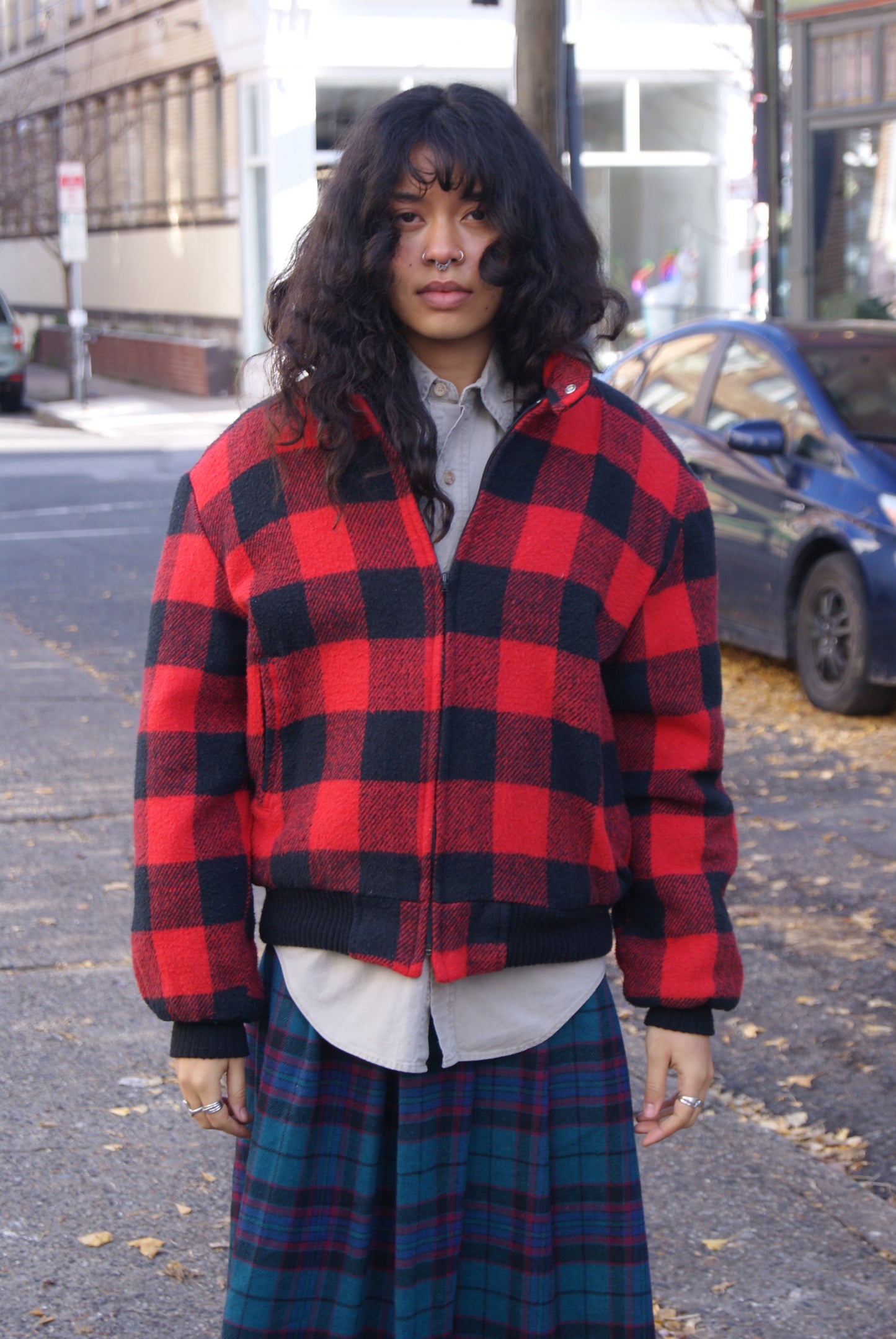 Model posing in red Sherpa-lined Buffalo Plaid Wool Bomber Jacket on the streets of South Philadelphia.