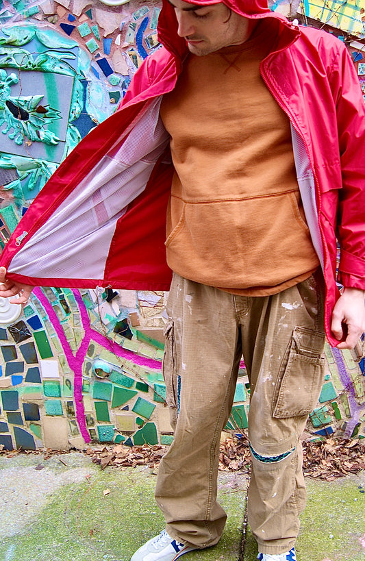 Male model wears one-of-a-kind tan Carhartt cargo work pants with uinique patchwork repair from a Mexican traditional blanket